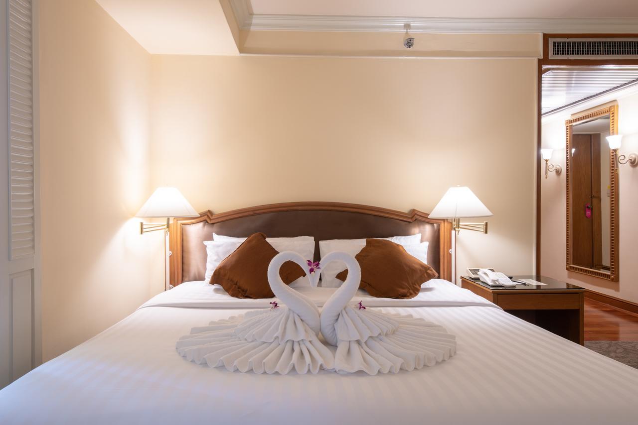 Montien Riverside Hotel Bangkok Exterior photo A bed with a towel swan